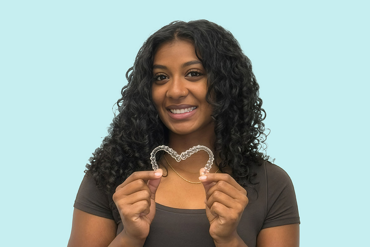 Patient holding up Invisalign clear aligners