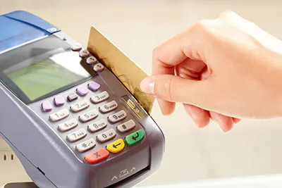 Hand swiping credit card at payment terminal